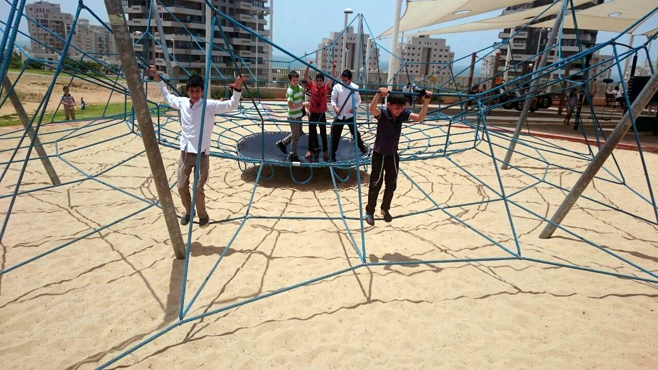 Some Zion boys stopping off at a sand-filled playground on their way to the beach on the Mediterranea...