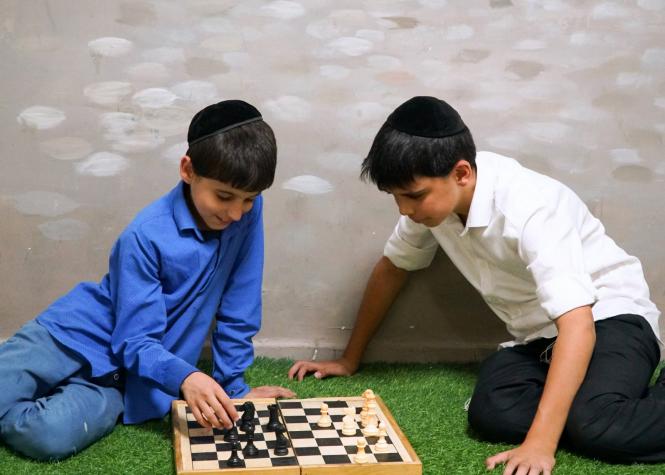 A couple of Zion boys are captured enjoying chess. This competitive game, according to historians...