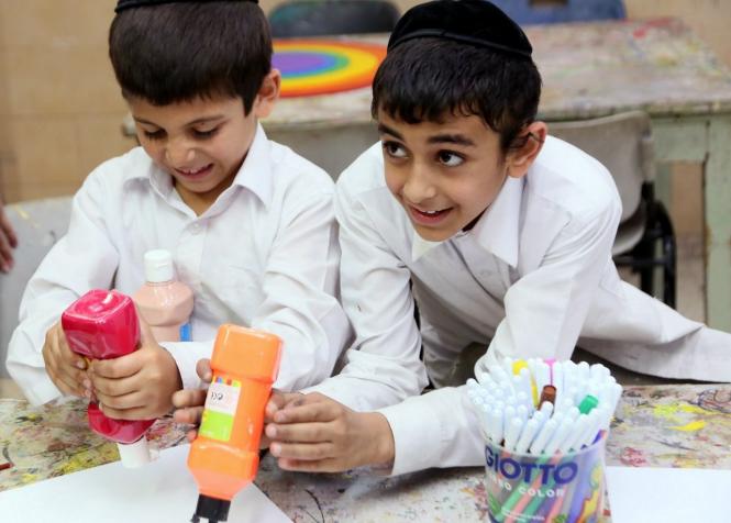 Un duo de garçons de l'Orphelinat Zion participent avec entrain à une classe d'art et d'artisana...