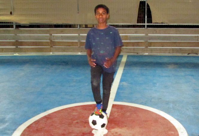 A Zion boy prepares to begin a soccer match with some friends on our campus rooftop soccer field.